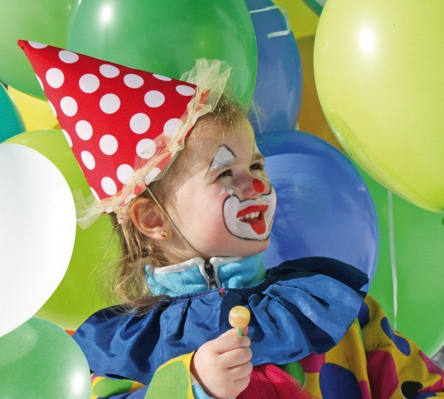 Kind ist als Clown verkleidet